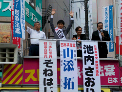赤羽駅東口にて、街頭演説会、手を挙げる山添拓弁護士