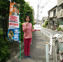 路地裏でハンドマイク宣伝をする山崎たい子区議